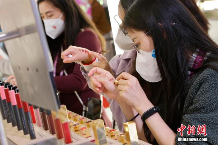 圖為女生正在體驗(yàn)口紅產(chǎn)品。 殷立勤 攝